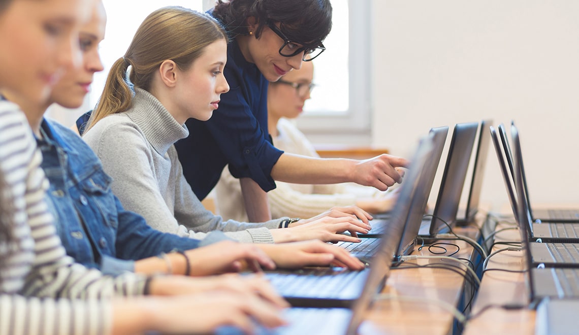 Educator training someone on a computer